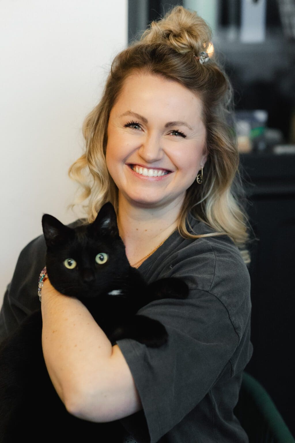 Ann-Kristin Chus lacht mit ihrer schwarzen Katze auf dem Arm