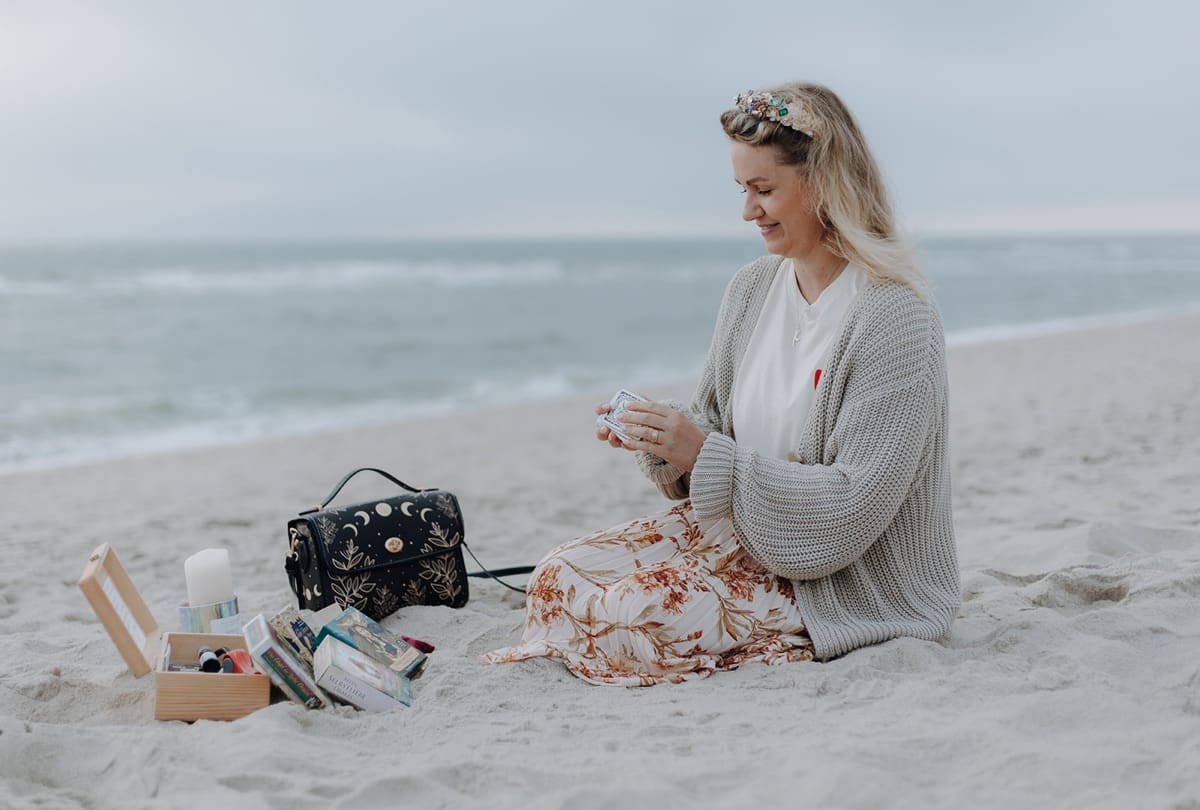 Ann-Kristin Chus mit ihren Karten am Strand von Sylt